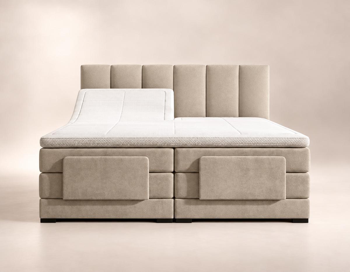
Beige Lumière elektrische boxspring met hoofdbord met verticale banen, witte topper en verhoogde linkerbedhelft in een lichte studio.