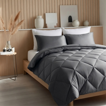 Antraciet all year dekbed zonder overtrek op opgemaakt bed in hoekperspectief met Scandinavische slaapkamer en pampasgras