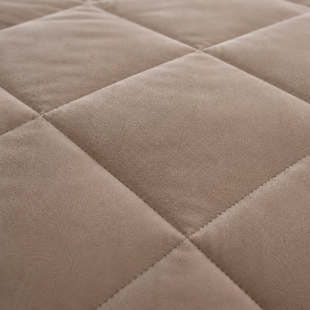 Close-up van zacht taupe velvet dekbed zonder overtrek met zichtbare quilting en fijne stofstructuur